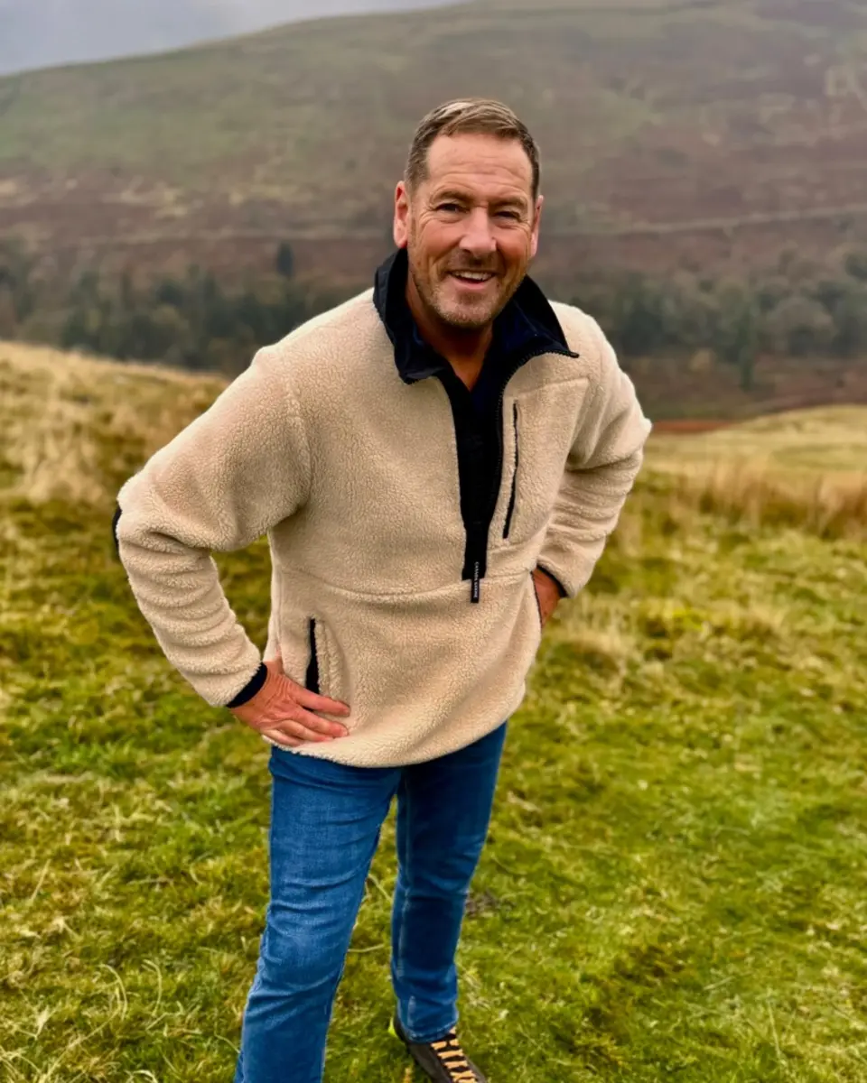 James Slater, Percy’s greenhouse worker, smiling on a grassy hillside